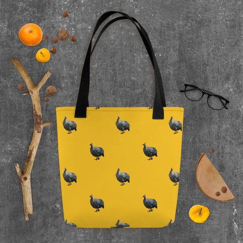 Sturdy yellow tote bag with guinea fowl and a black handle. Laid on an autumn background
