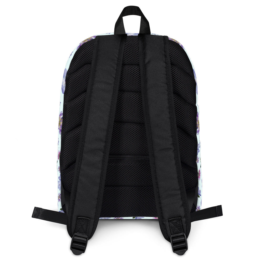 Back of light blue backpack with a blue and purple floral pattern