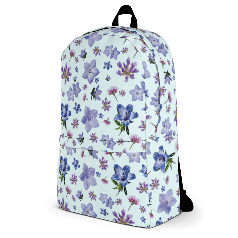 Side of light blue backpack with a blue and purple floral pattern