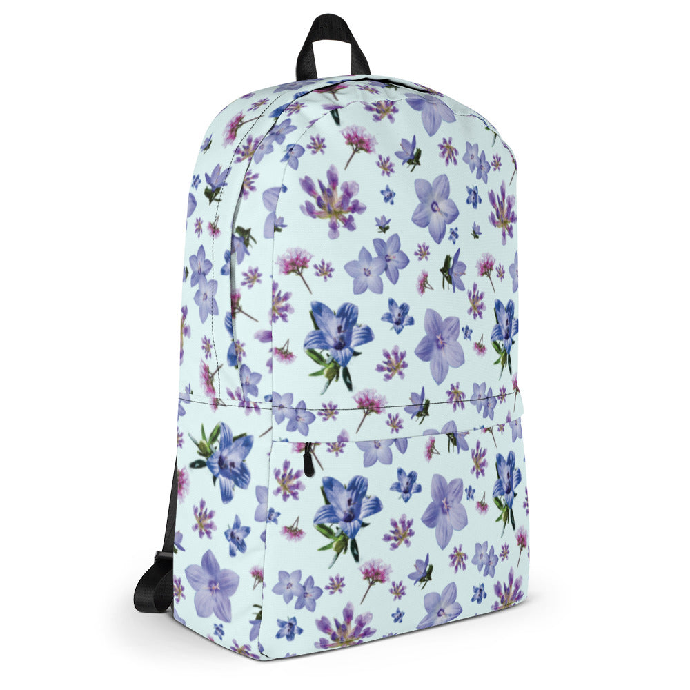 Side of light blue backpack with a blue and purple floral pattern